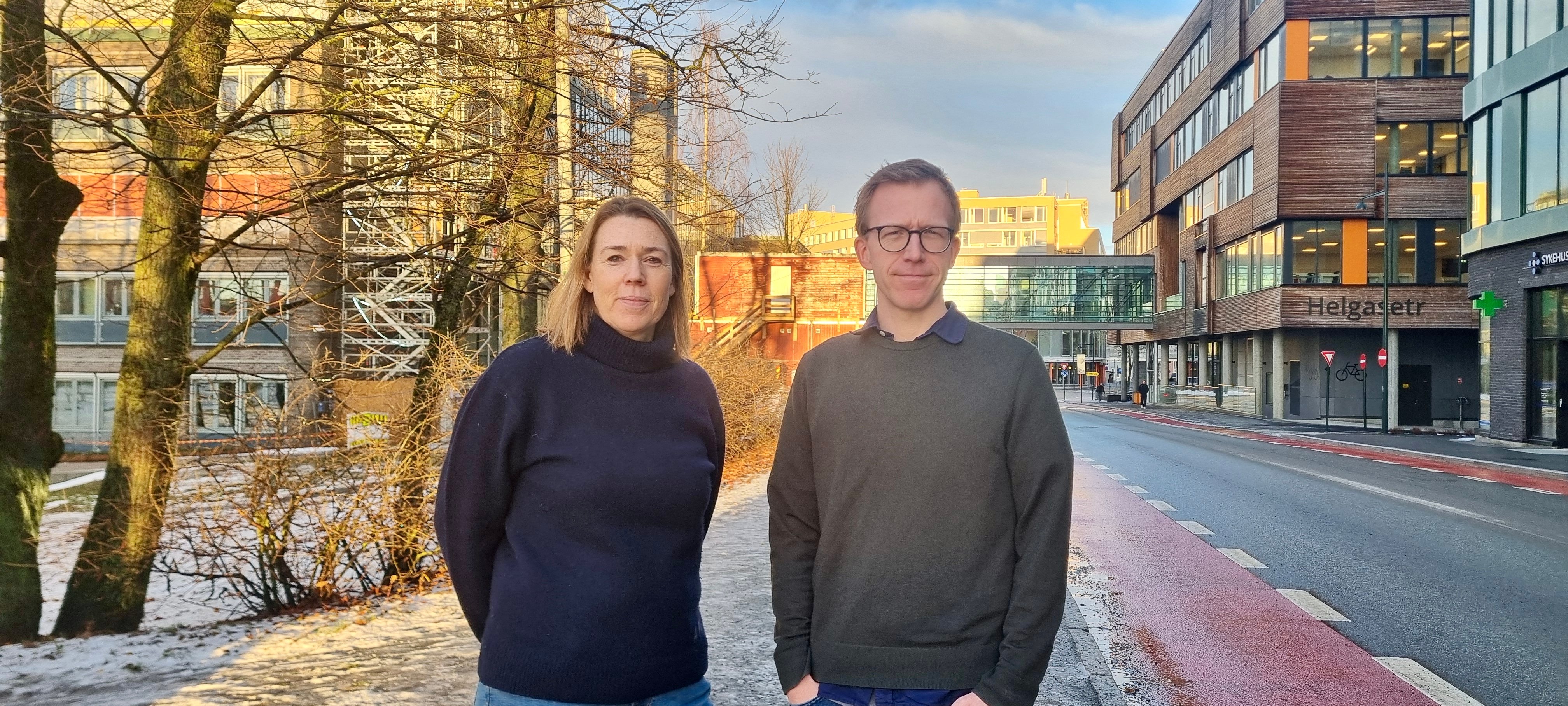 En mann og en kvinne står i en gate med bygninger på hver side