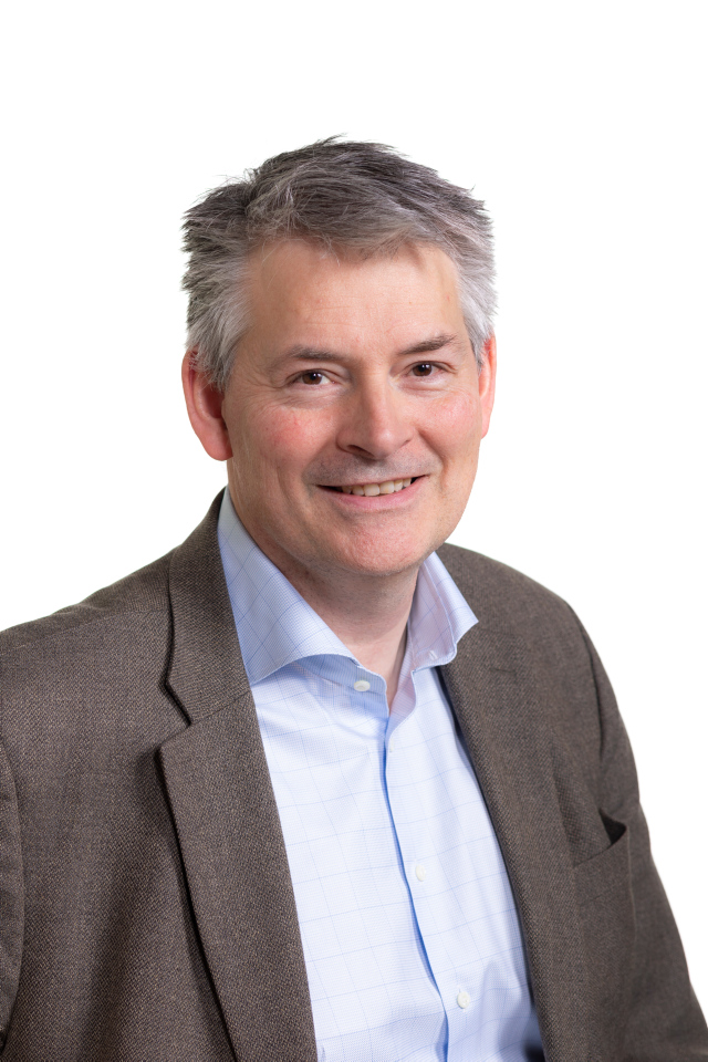 En mann i dress som smiler