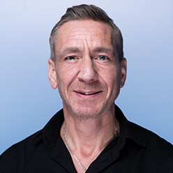 En mann som smiler til kameraet