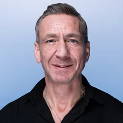 En mann som smiler til kameraet