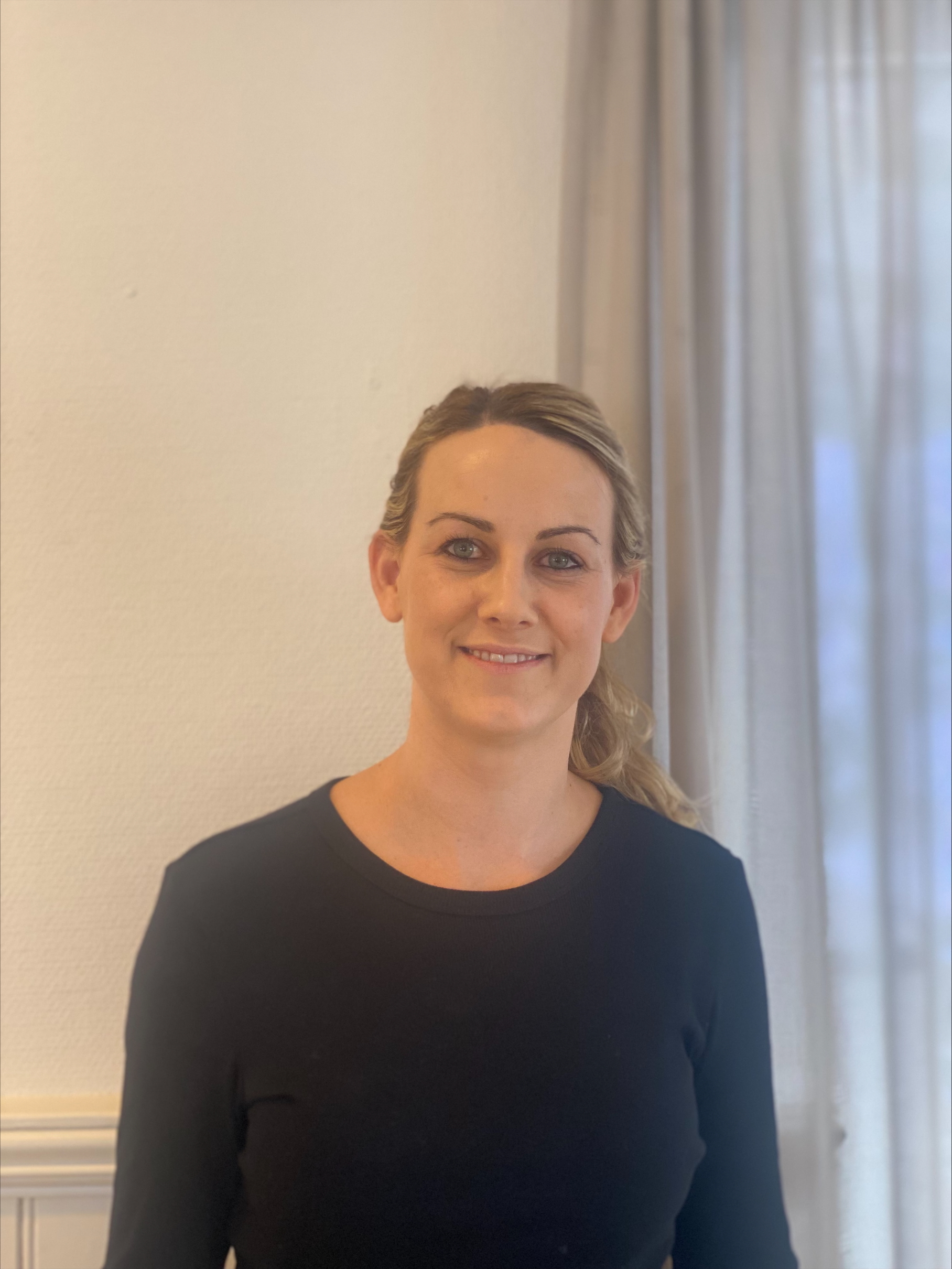 En person som smiler til kameraet