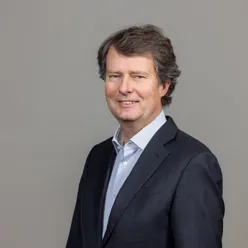 En mann i dress som smiler