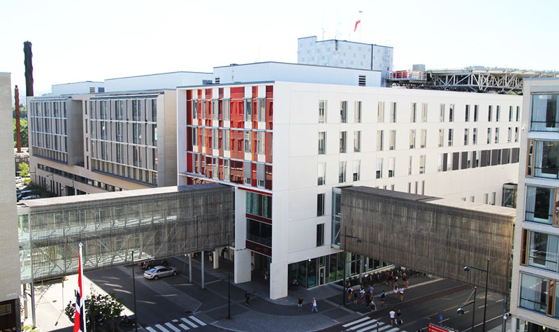 En stor hvit bygning med en gate og folk som gikk rundt