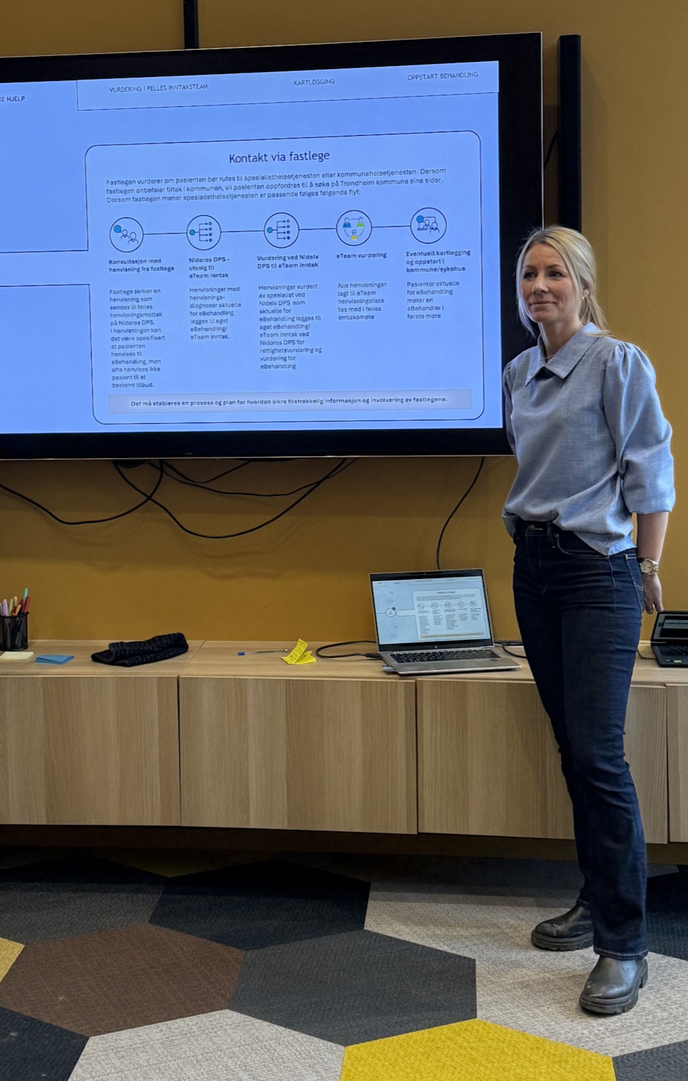 En person som står foran en stor skjerm