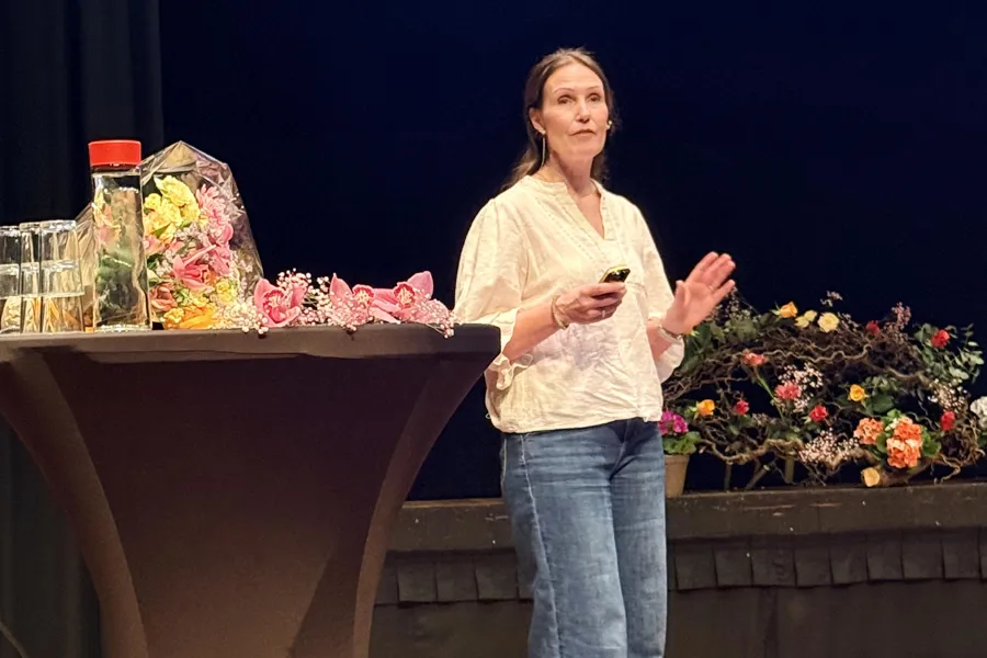 En person som står foran et podium med blomster og en mikrofon