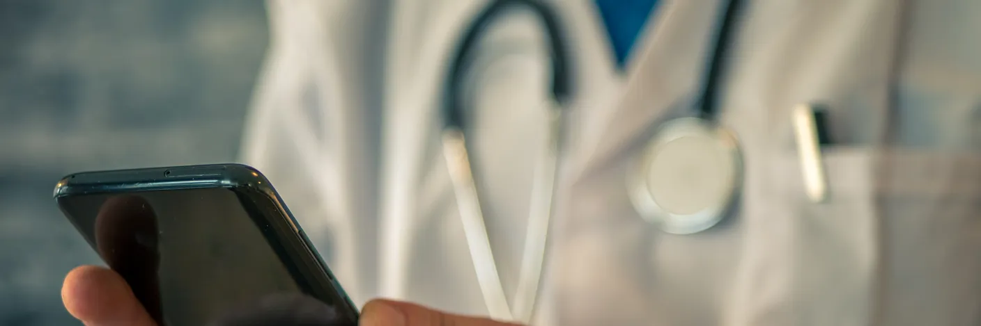 En lege som bruker mobiltelefon