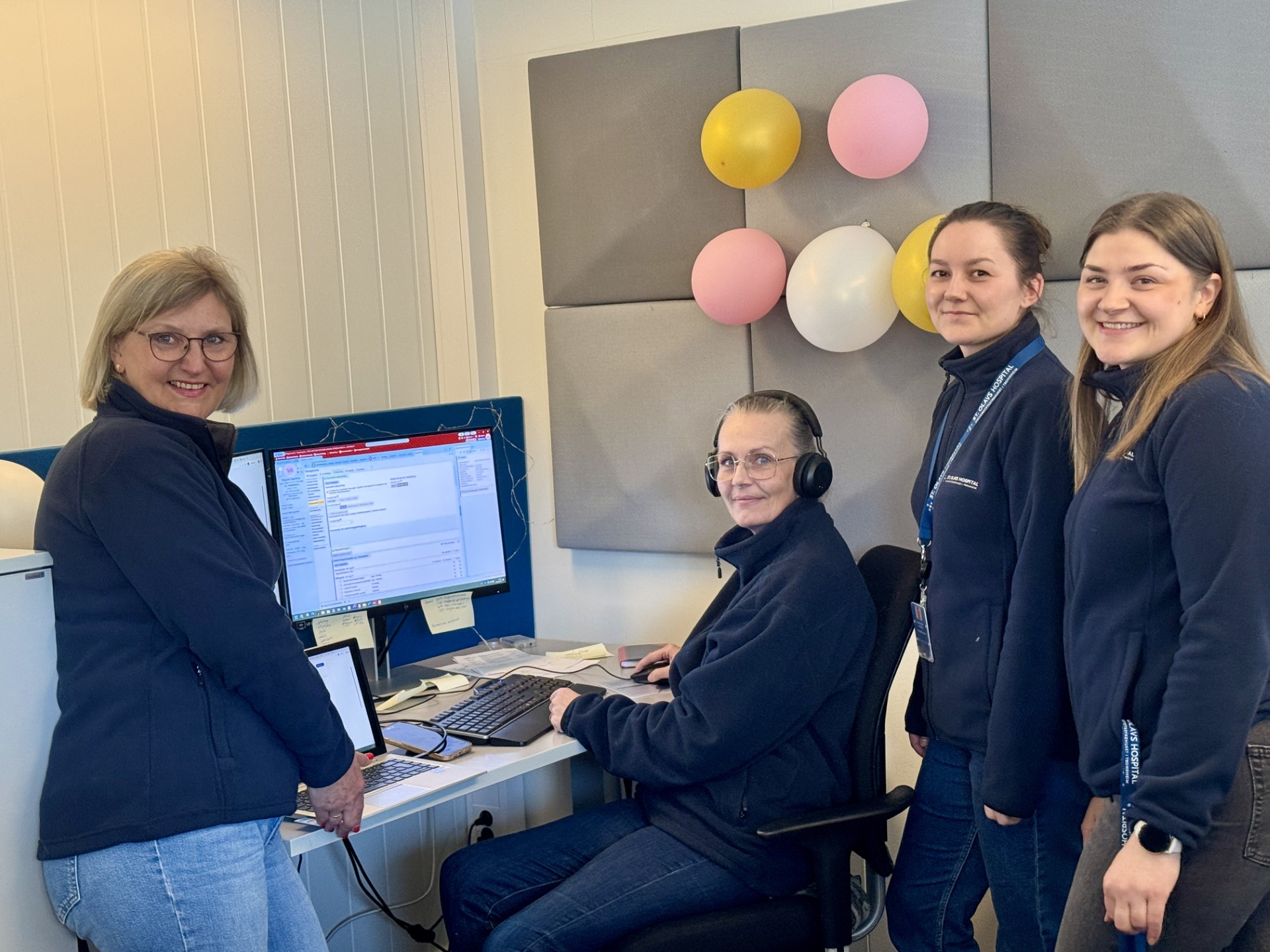 En gruppe mennesker som står rundt en datamaskin