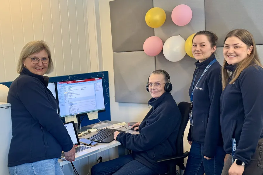 En gruppe mennesker som står rundt en datamaskin