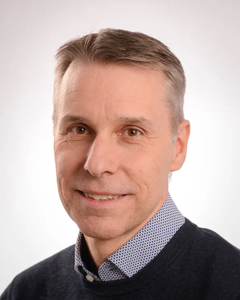 En mann som smiler til kameraet