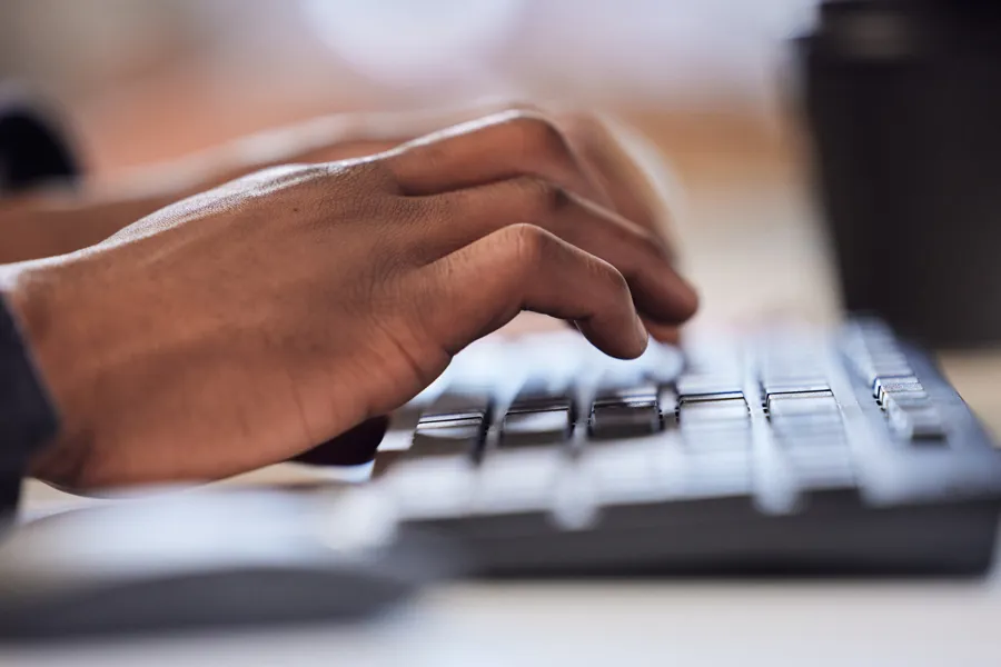Et nærbilde av en hånd som taster på et tastatur