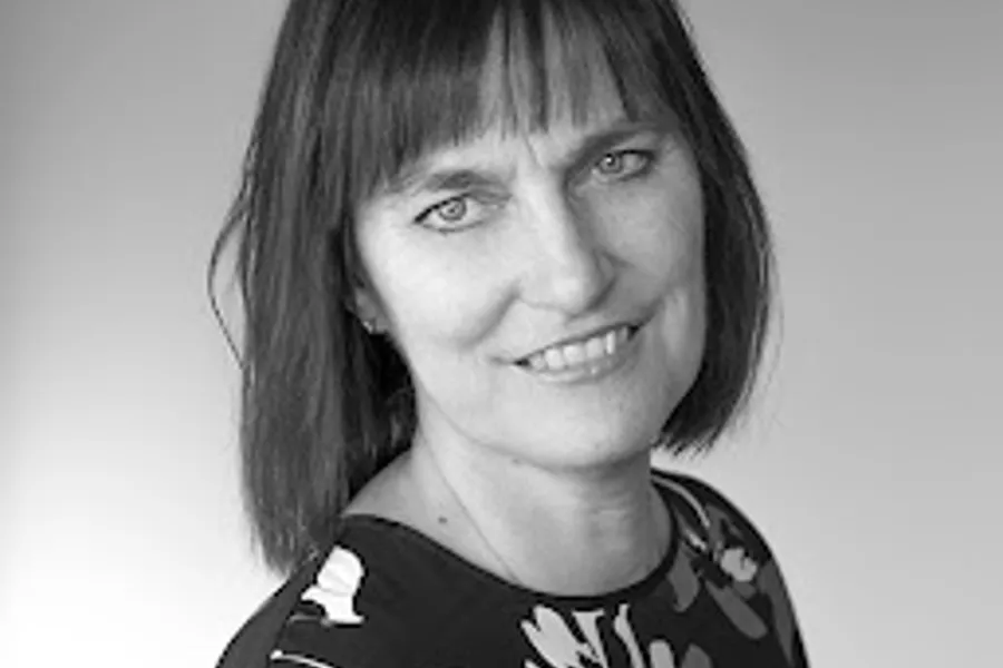 En kvinne som smiler til kameraet