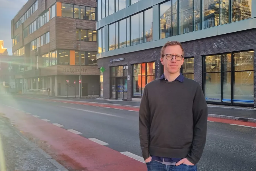 En mann som står foran en bygning