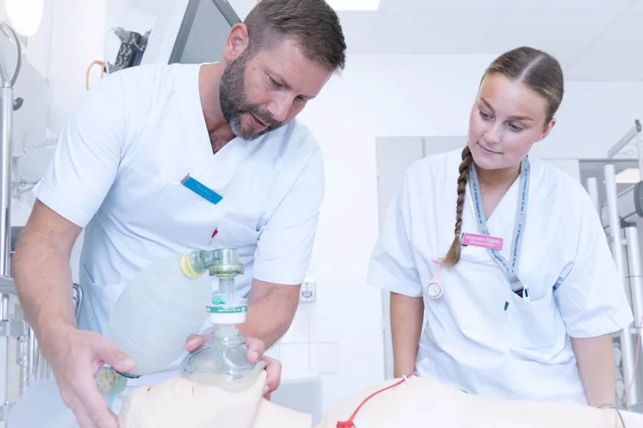 En mann og en kvinne i hvite laboratoriefrakker som ser på en plastflaske