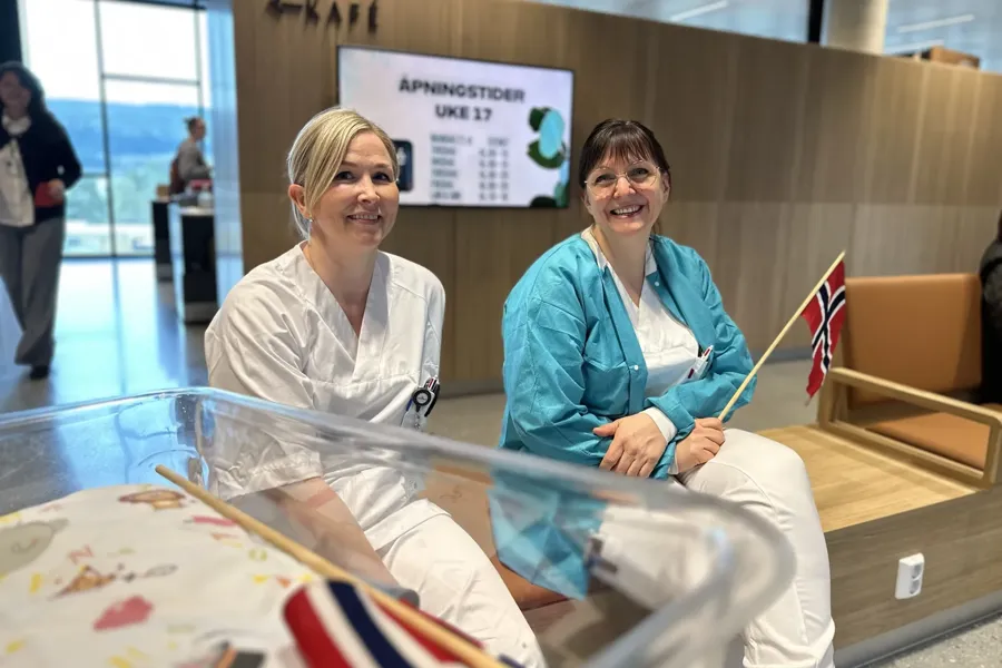 Kvinner i hvite frakker sitter på en benk