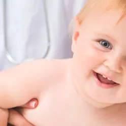 En baby med en hånd i ansiktet