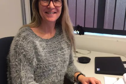 En kvinne som sitter ved et skrivebord