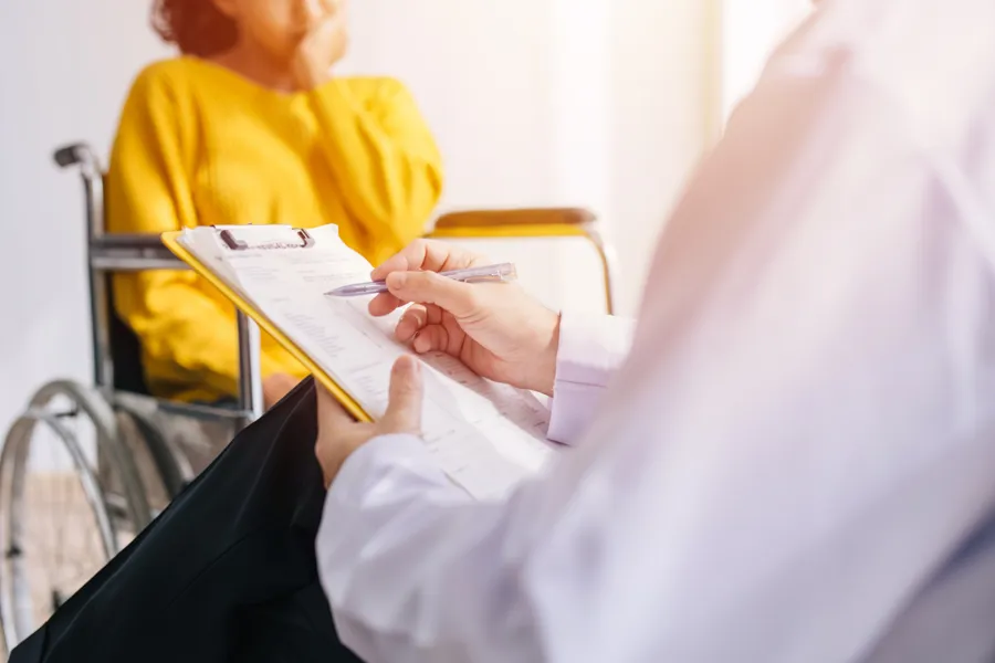 En lege som holder en utklippstavle