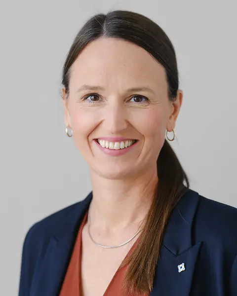 En kvinne som smiler til kameraet