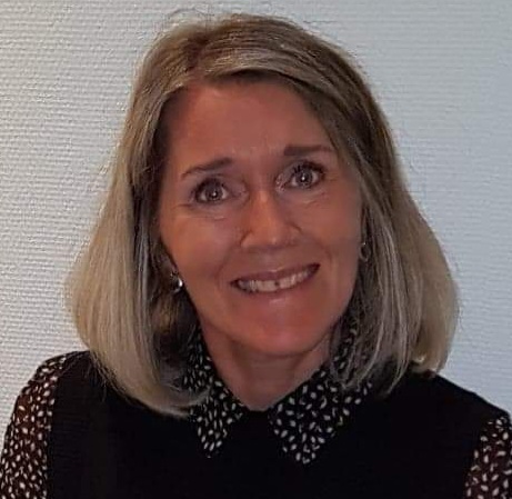 En kvinne som smiler til kameraet