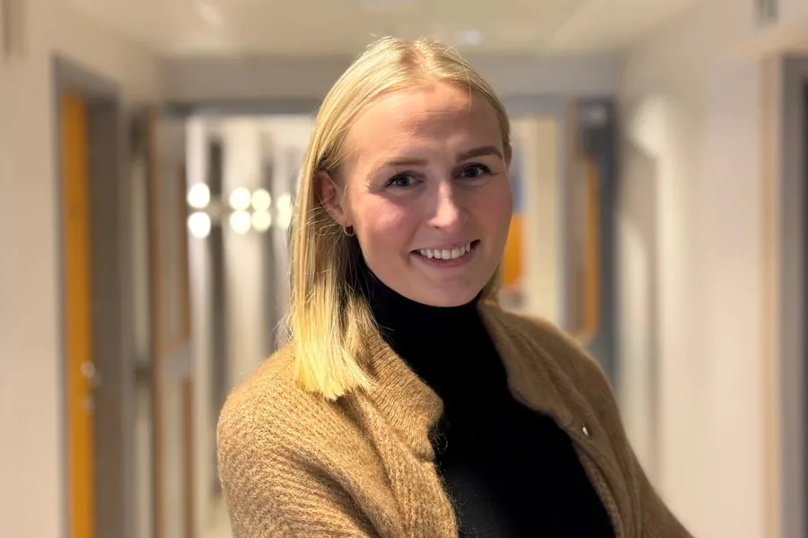 En kvinne som smiler til kameraet