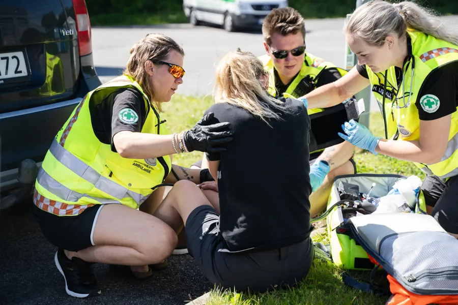En gruppe mennesker i sikkerhetsvester som jobber på en bil