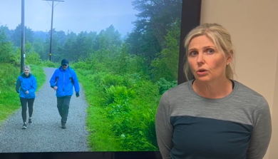En kvinne som ser på en mann som går på en sti med trær og gress