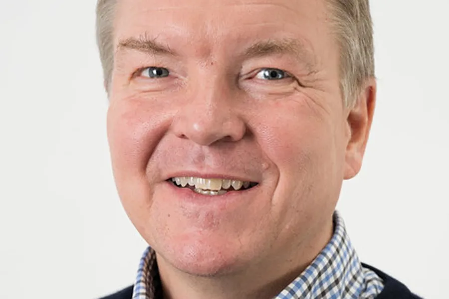 En mann som smiler til kameraet