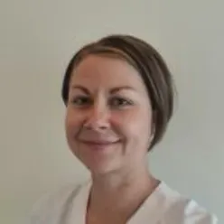 En kvinne som smiler til kameraet