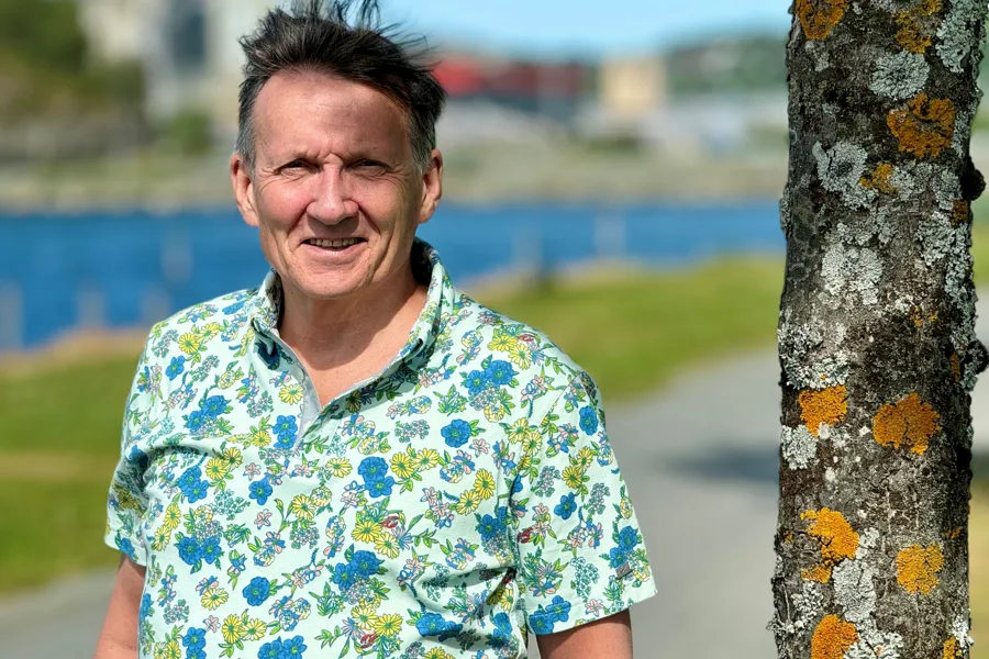 En mann som står ved siden av et tre