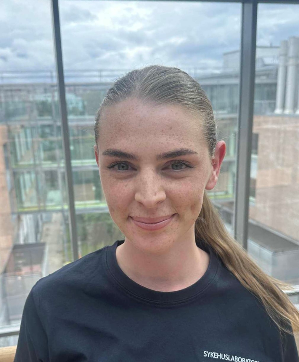 En kvinne som smiler til kameraet