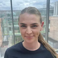 En kvinne som smiler til kameraet