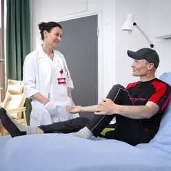 En kvinne og en mann som sitter på en seng