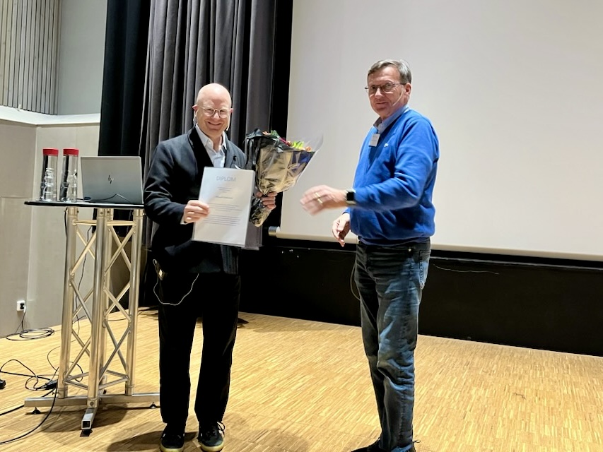 Et par menn som holder et stykke papir