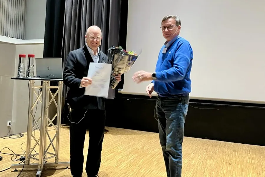 Et par menn som holder et stykke papir